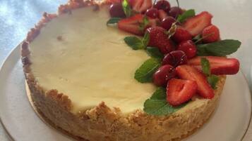 Un gâteau au fromage garni de fraises et de cerises.