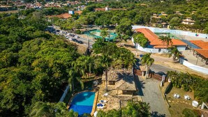 An aerial view of a resort with a swimming pool, outdoor seating, and a view of the surrounding landscape. - Bz92 Casa 600m Rua das Pedras 4 suítes (Buzios)