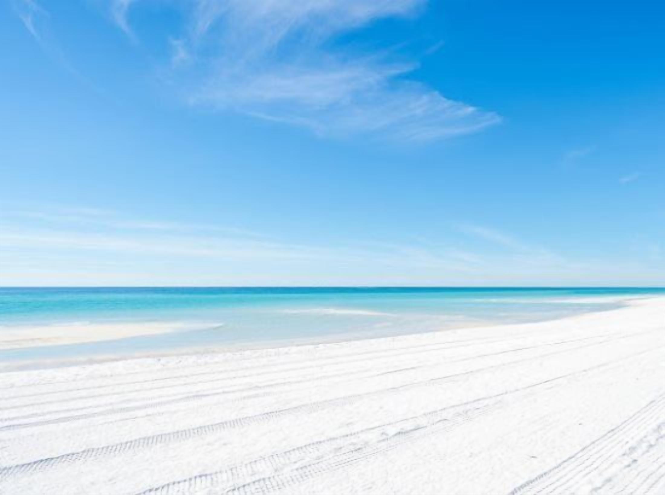 A beach with a clear sky and a sandy shore.