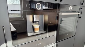 Una cocina moderna con cafetera integrada y horno Bosch.