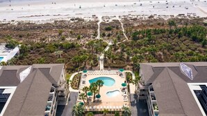 An aerial view of a hotel with a swimming pool, surrounded by a landscaped area with palm trees and a beach in the background. - Fun Oceanfront Villa w/ Pool on Hilton Head (Hilton Head Island)