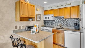 A kitchen with wooden cabinets, a microwave, a toaster, and a coffee maker. - Fun Oceanfront Villa w/ Pool on Hilton Head (Hilton Head Island)