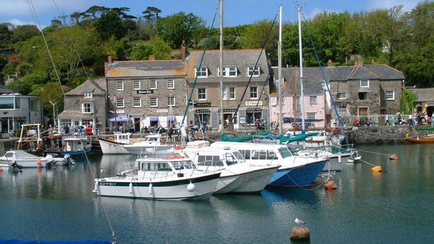 A harbor with several boats docked, a stone building with a sign, and a backdrop of trees. - Padstow Holiday Home 2 Bedrooms, wifi, rear decked patio, pets welcome - parking (Padstow)