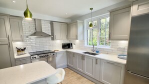 Una cocina moderna con una isla central, electrodomésticos de acero inoxidable y un ventanal que proporciona luz natural.
