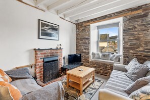 A cozy living room with a fireplace, a television, and a comfortable sofa.