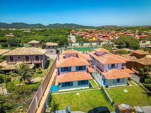 A residential area with houses featuring red-tiled roofs and a mix of single and two-story buildings. - Bz93 Cond pé na areia piscina privativa (Buzios)