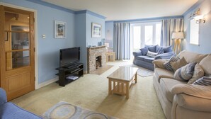 A living room with a fireplace, a television, a sofa, and a coffee table.