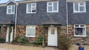 A row of terraced houses with stone and slate exteriors, white-framed windows, and a gravel front garden. - Kegyn - Harlyn Bay Cornwall,  sleeps 5 guests & accepts pets (Harlyn Bay)