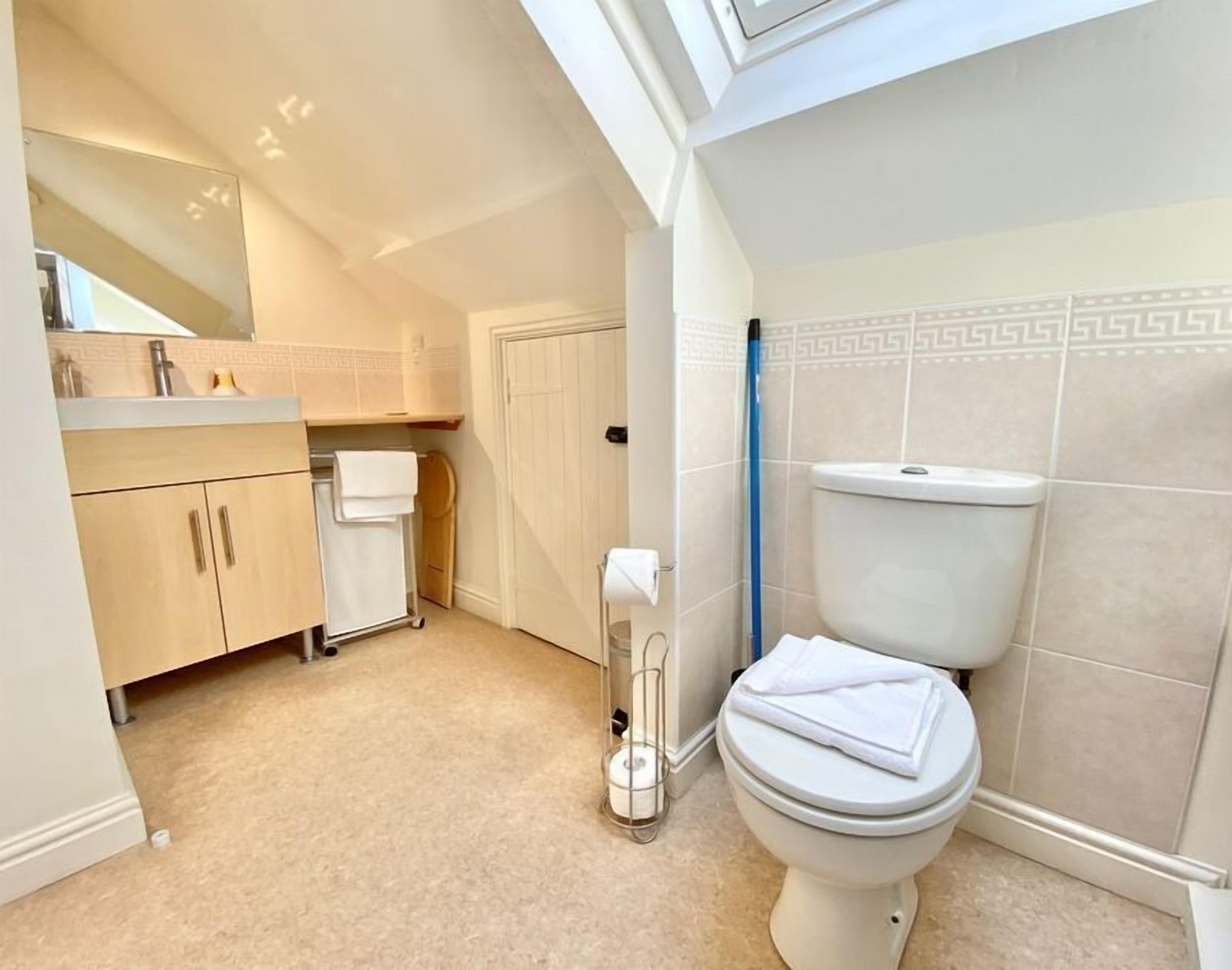 A bathroom with a toilet, sink, and mirror.