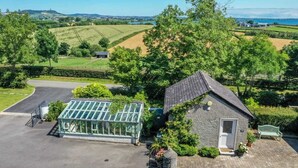 A house with a greenhouse, a small shed, and a paved driveway. - The Stables at Ballygraffan, just outside Comber in the Strangford Lough area. (Comber)