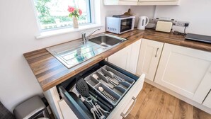 A compact kitchen with a built-in sink, a microwave, a kettle, and a drawer organizer with utensils. - The Stables at Ballygraffan, just outside Comber in the Strangford Lough area. (Comber)