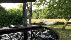 A wooden barrel with a metal stand, a hammock, and a small table with a keyboard. - Farmhouse paradise with meadows, forests, animals (Issigeac)