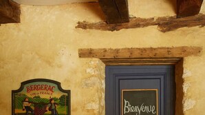 A door with a "Bienvenue chez vous" sign and a "Bergerac Vin de France" sign on the wall. - Farmhouse paradise with meadows, forests, animals (Issigeac)