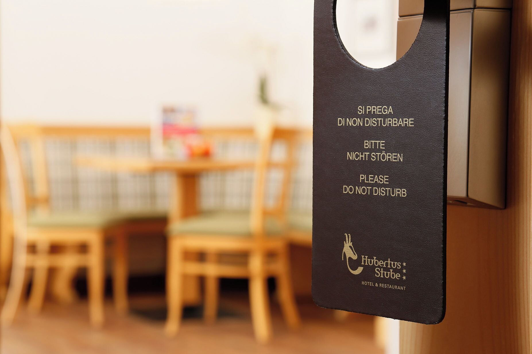 Un panneau noir avec du texte rédigé dans plusieurs langues, fixé à un mur, indiquant une zone où le silence est de rigueur.