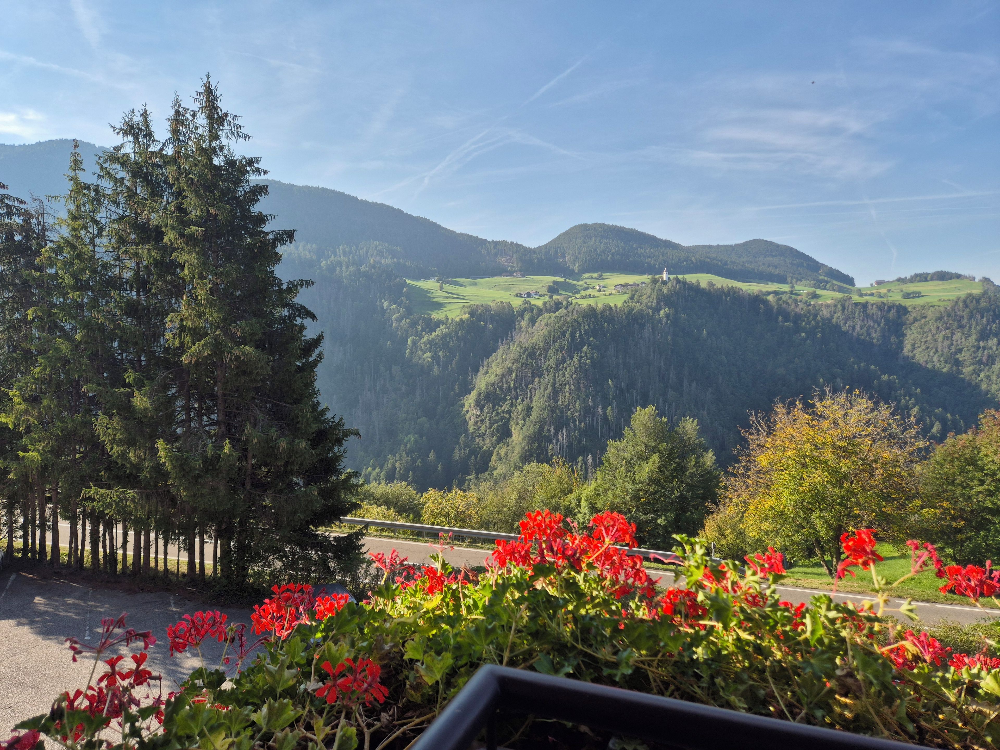 A view of a mountainous landscape with a road in the foreground and a clear sky.