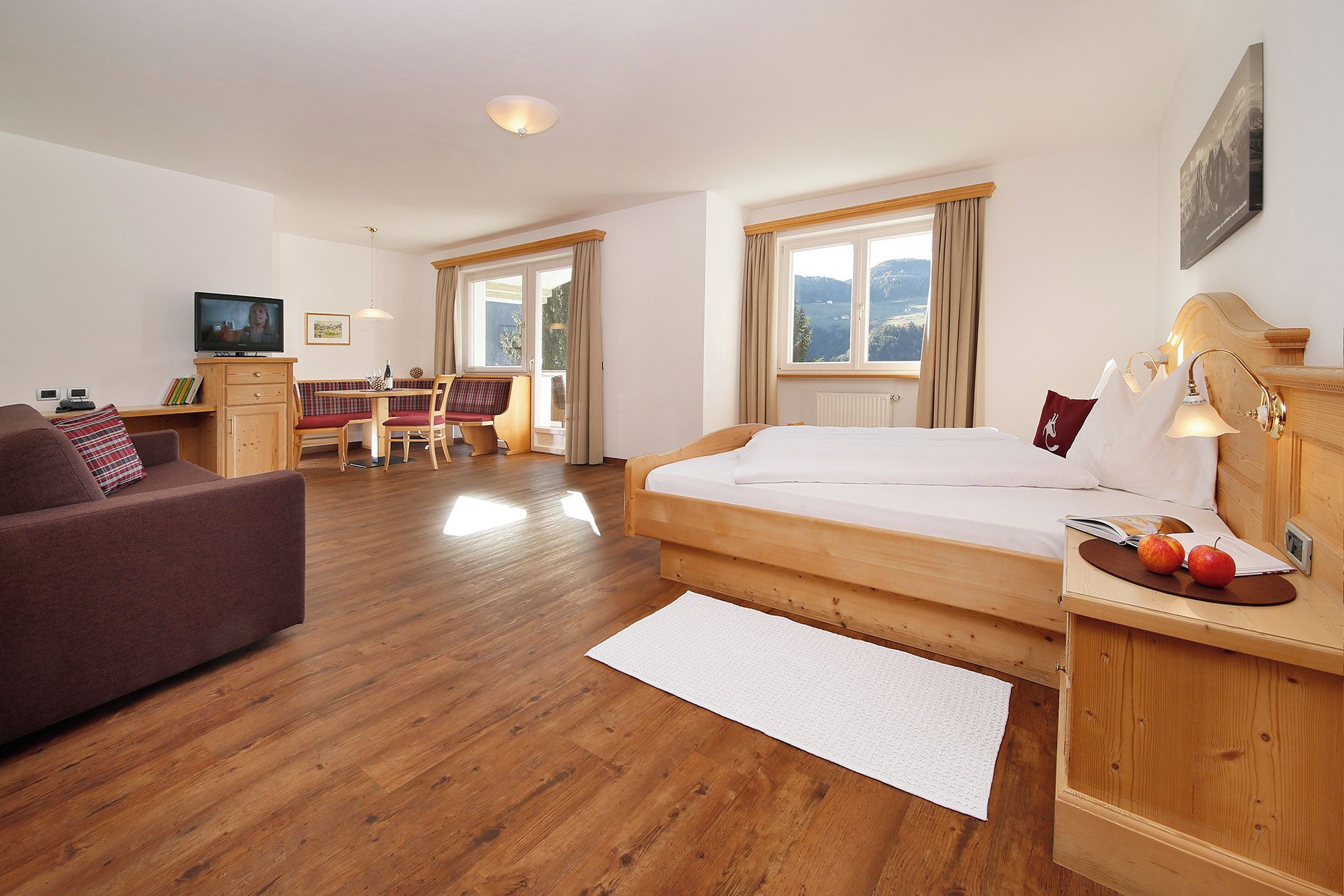 Une chambre d’hôtel équipée d’un lit, d’un bureau, d’une chaise, d’un canapé et d’une télévision.