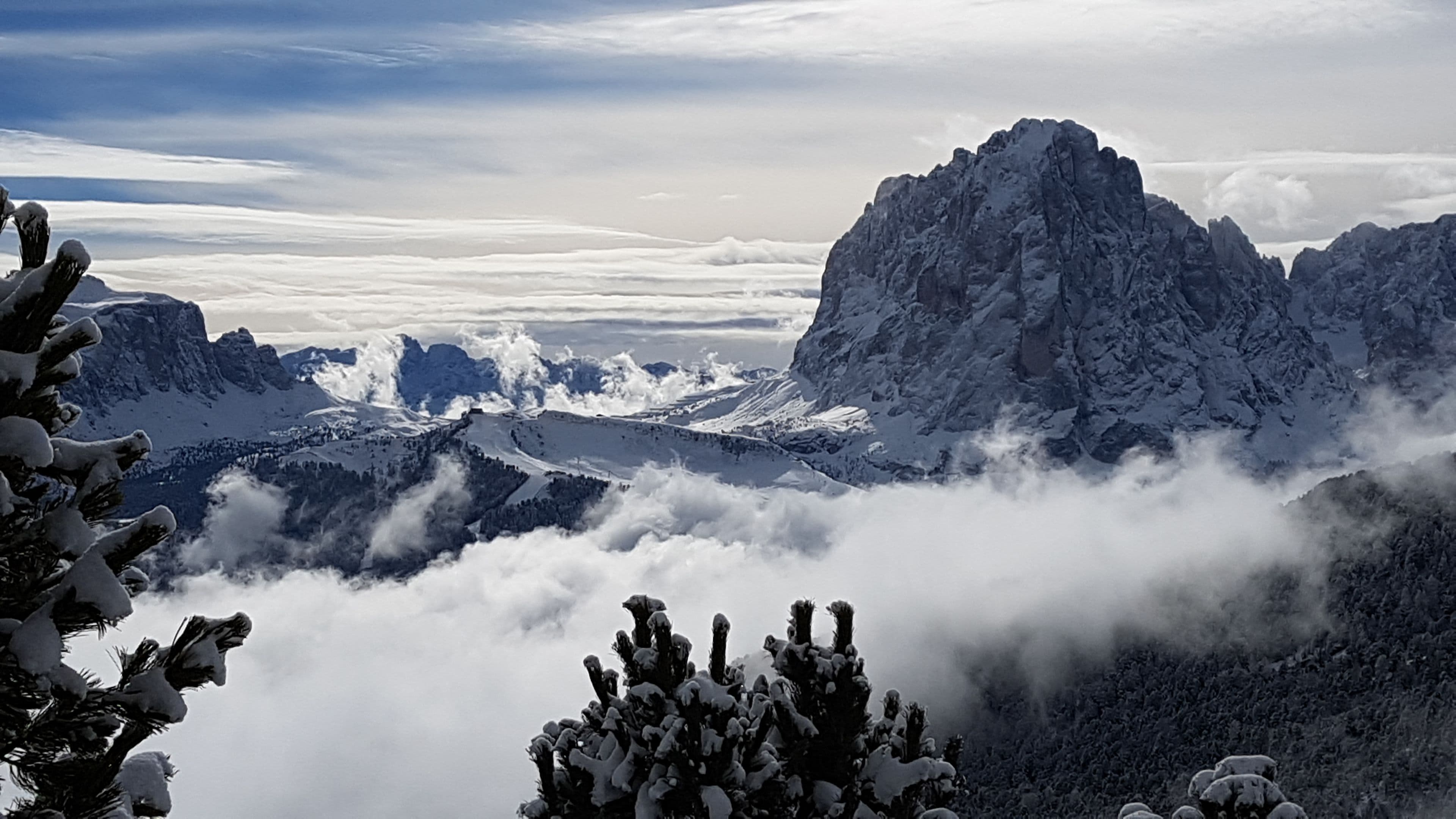 A mountainous landscape with snow-covered peaks and trees.