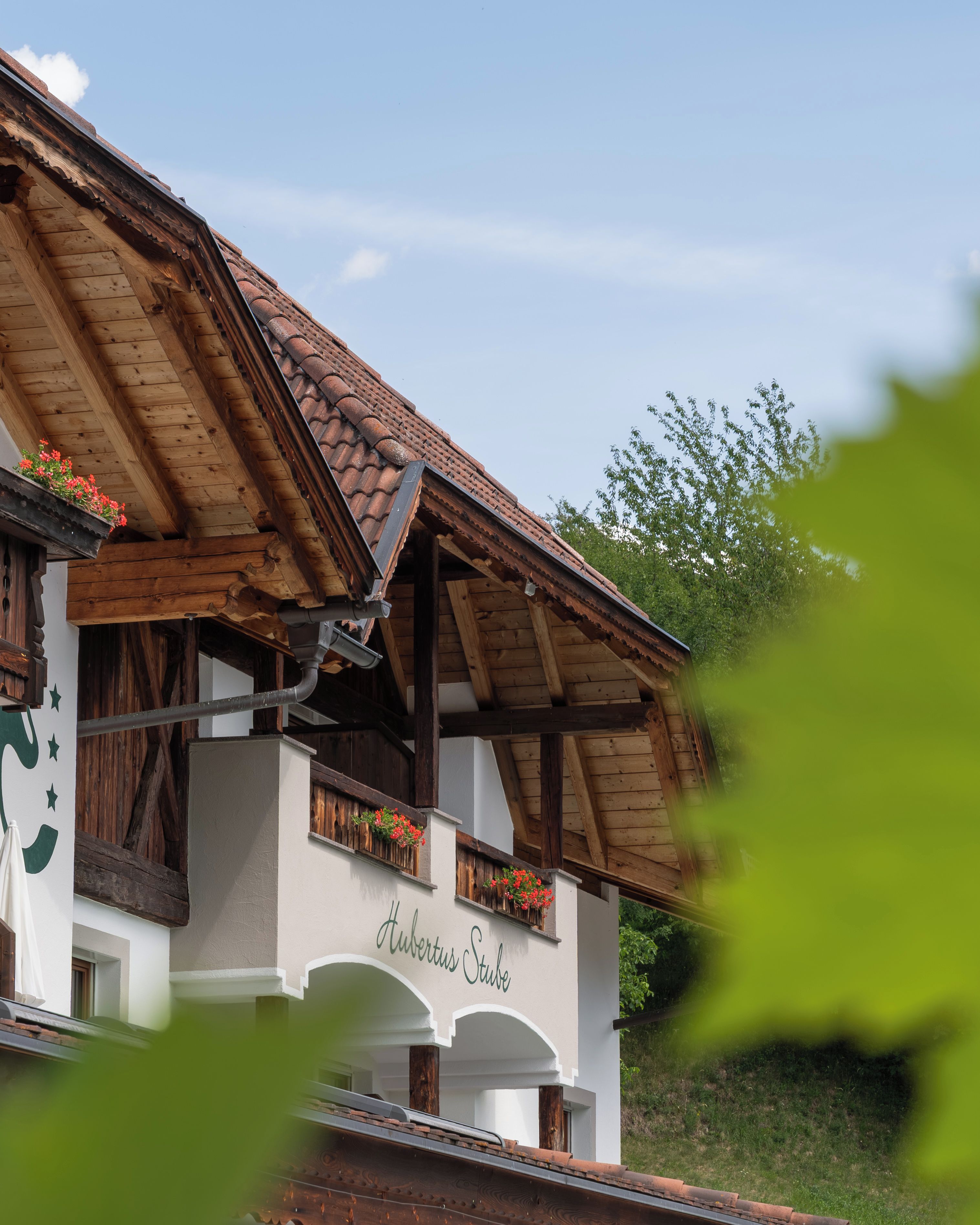 Un tipico chalet con tetto spiovente, travi in legno e fioriere sul balcone.