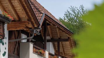 Un tipico chalet con tetto spiovente, travi in legno e fioriere sul balcone.