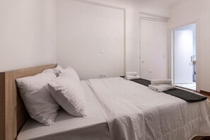 Cozy retreat with a single bed, neatly made with white linens and pillows, and a small table with a folded towel.