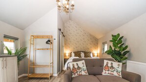 Une pièce chaleureuse avec un lit superposé, un canapé agrémenté de coussins à motifs de canards, une table basse en bois et une grande plante.