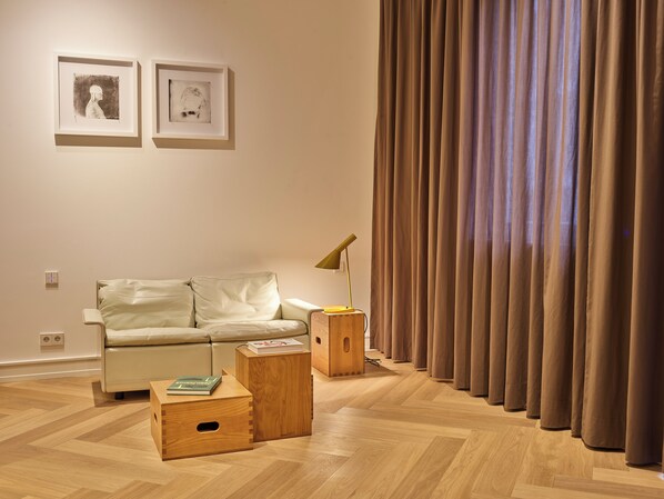 A modern living room with a sofa, wooden side tables, and a lamp. - Townhouse by THE QVEST (Cologne)