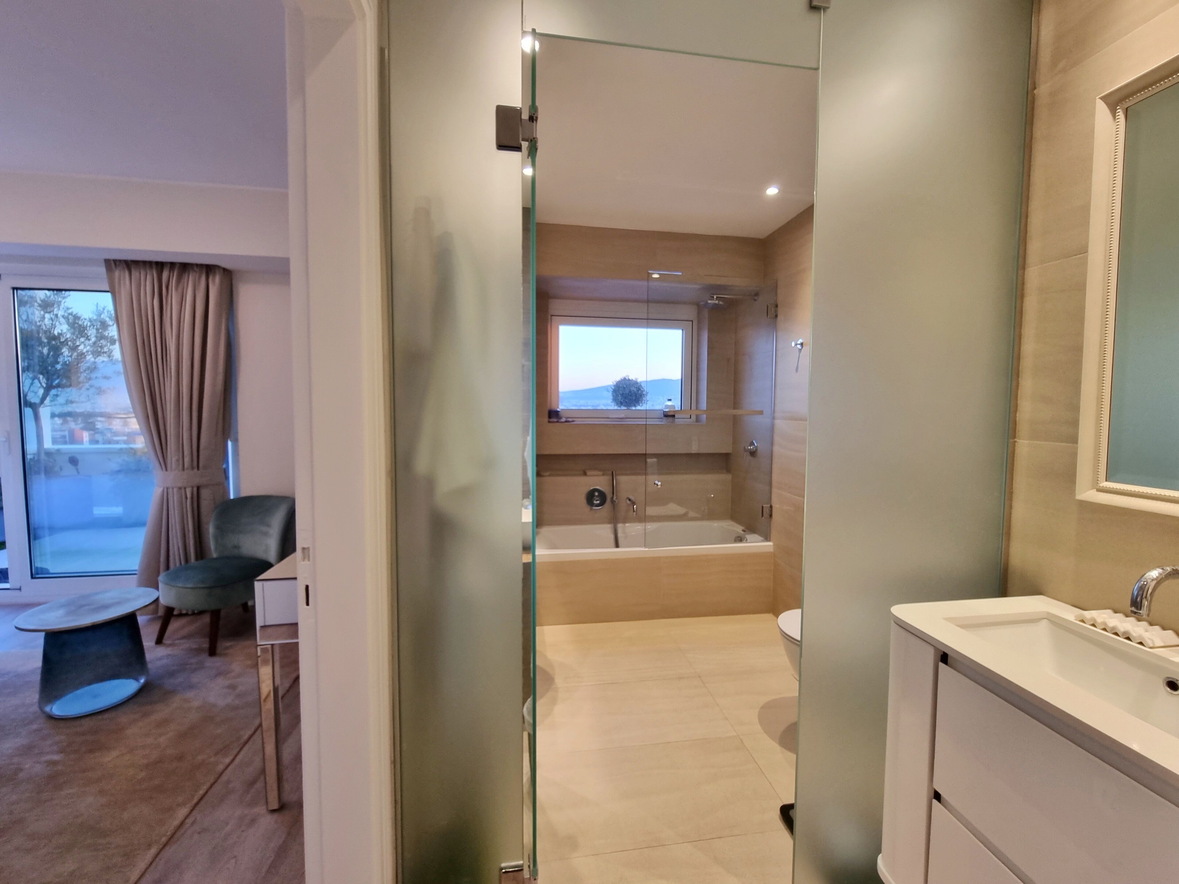 Une salle de bain moderne dotée d’une douche à parois de verre, d’une baignoire et d’un meuble-lavabo avec un miroir.