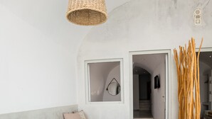 Un spa moderno con una bañera grande, una planta de madera y una lámpara de fibra.