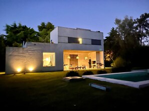 A modern two-story house with a swimming pool, large windows, and outdoor lighting. - Country House Mediterranean With Pool (City Bell)