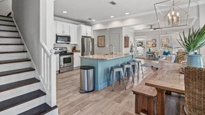 A spacious kitchen with a central island, stainless steel appliances, and a modern chandelier. - 4BR Seacrest Beach Home w/ Pool, Free Tram Service + Attraction Tickets! (Panama City Beach)