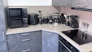 A modern kitchen with a microwave, coffee maker, toaster, and a dishwasher. - Familien Suite in Elbflorenz (Dresden)