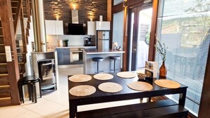 Une cuisine moderne dotée d’un îlot central, d’appareils électroménagers intégrés et d’un mur d’accent en pierre.