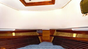 A compact, single-bed RV with a wooden interior, a small window at the top, and a built-in storage compartment under the bed. - Welcome to Your floating home-away-from-home: Calm, Cozy, and Unforgettable (Miami)