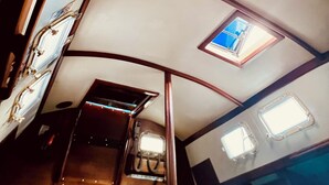 A narrow corridor with a skylight and a small window, leading to a door. - Welcome to Your floating home-away-from-home: Calm, Cozy, and Unforgettable (Miami)