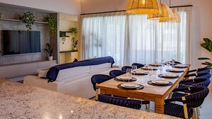 Un comedor moderno con una mesa de madera dispuesta para seis personas, rodeada de sillas tapizadas en tonos oscuros.