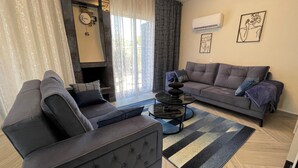 A modern living room with a sofa, a coffee table, and a fireplace. - Family Design Villa & Play Garden near Sea, 3 BR, Sea Views (Chlorakas)