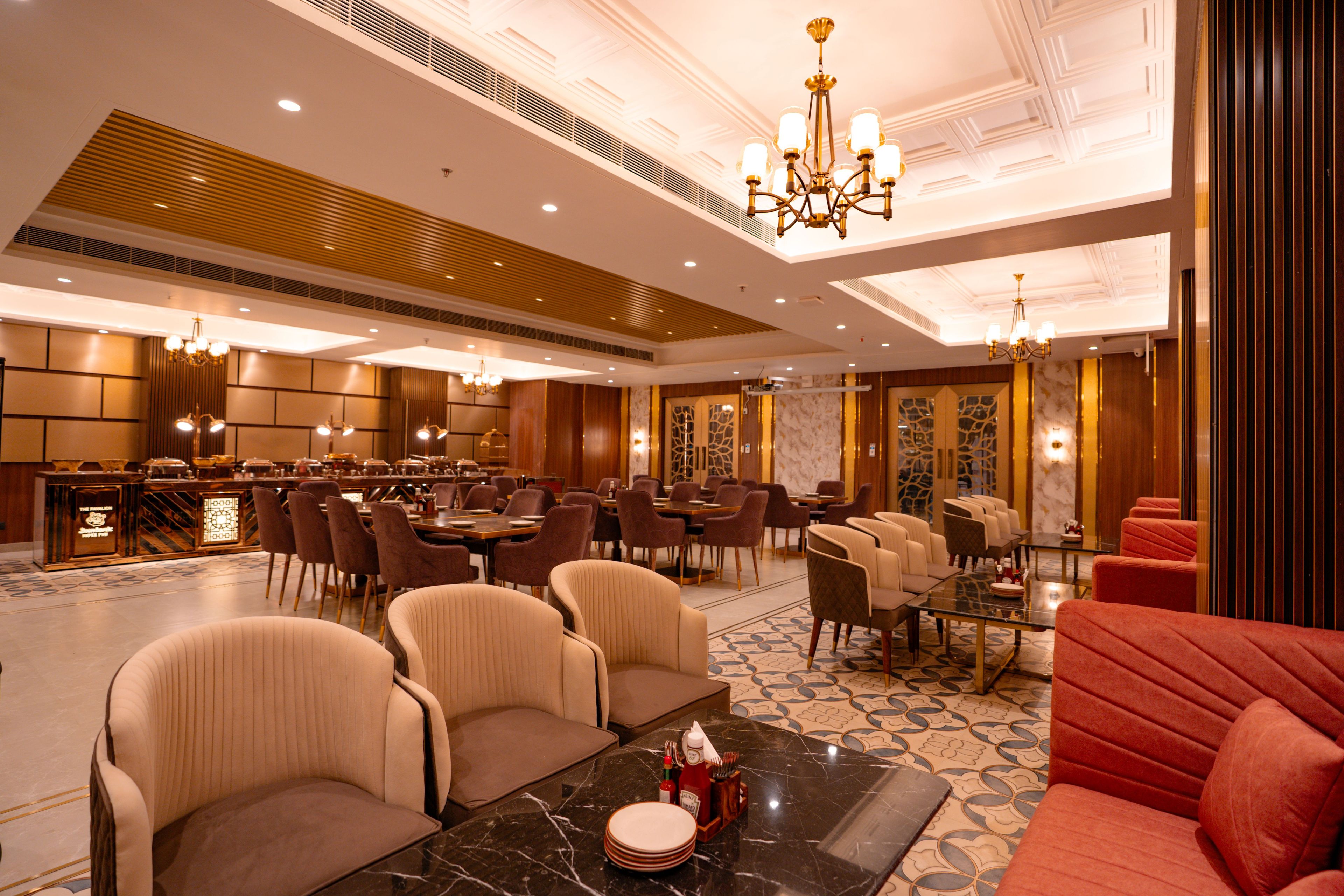 A hotel lobby with a bar, seating areas, and a chandelier.