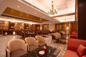 A hotel lobby with a bar, seating areas, and a chandelier. - Hotel D Palace (Dhaka)
