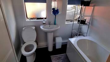 A compact bathroom with a toilet, sink, and bathtub.