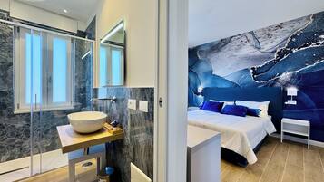 Camera con letto matrimoniale o 2 letti singoli, vista mare parziale | Bagno | Doccia, asciugacapelli, bidet, asciugamani