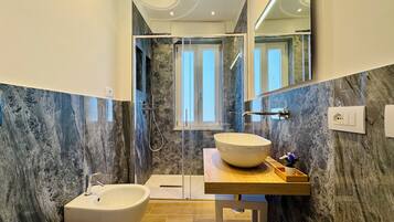 Camera con letto matrimoniale o 2 letti singoli, vista mare parziale | Bagno | Doccia, asciugacapelli, asciugamani, sapone