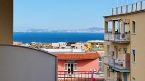 Une vue sur la côte, avec des bâtiments, un balcon et un ciel dégagé.