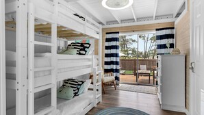 A bedroom with bunk beds, a wooden ceiling, and a view of the backyard through a sliding door. - 2BR Home, Private Heated Pool, 4 Bikes, Beach Access (Santa Rosa Beach)