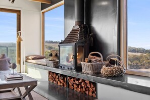A modern interior with a large window, a fireplace, and a view of the outdoors. - Janacwal - Where Escape Meets Adventure (Bells Beach)