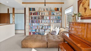 Um quarto com uma estante grande, um sofá, uma escrivaninha de madeira e um globo na parede.
