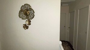 Ein Korridor mit weißer Handläufung, einem Wanddekor und einer Tür am Ende.