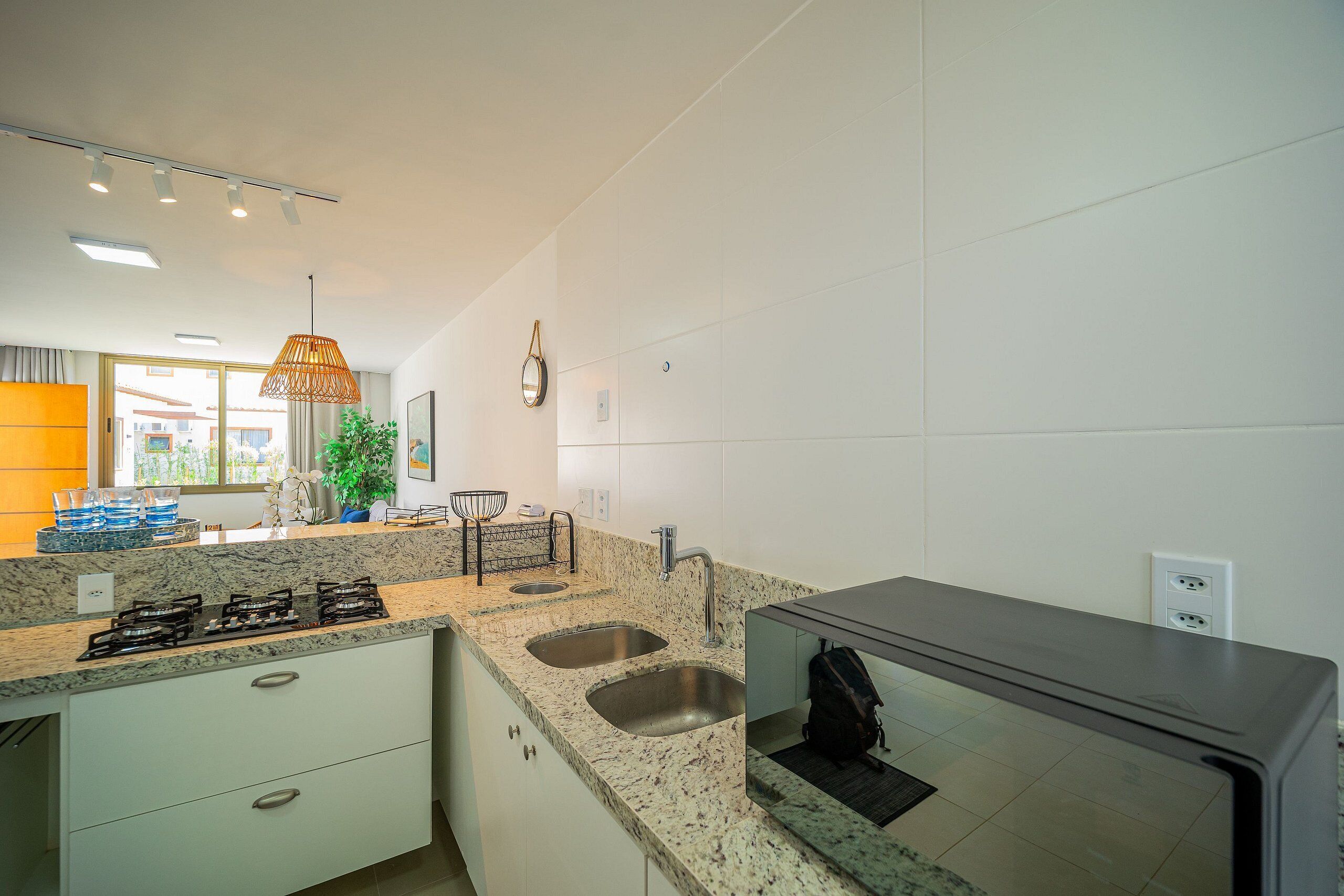 A modern kitchen with granite countertops, stainless steel sinks, and a built-in oven.