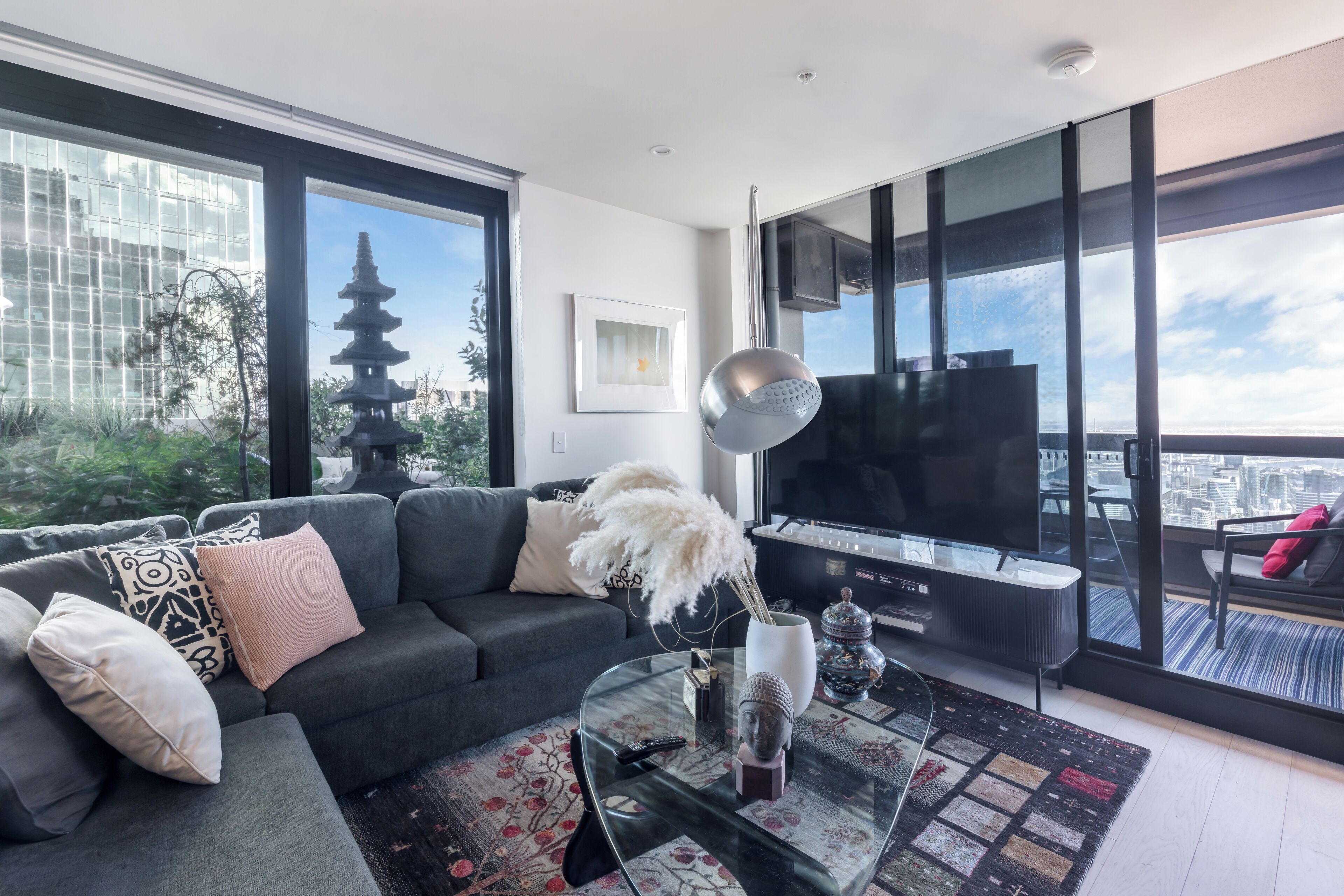 Unwind in a living space where bold black walls meet vibrant art and curated sculpture—a lounge that feels like your own private gallery in the sky.