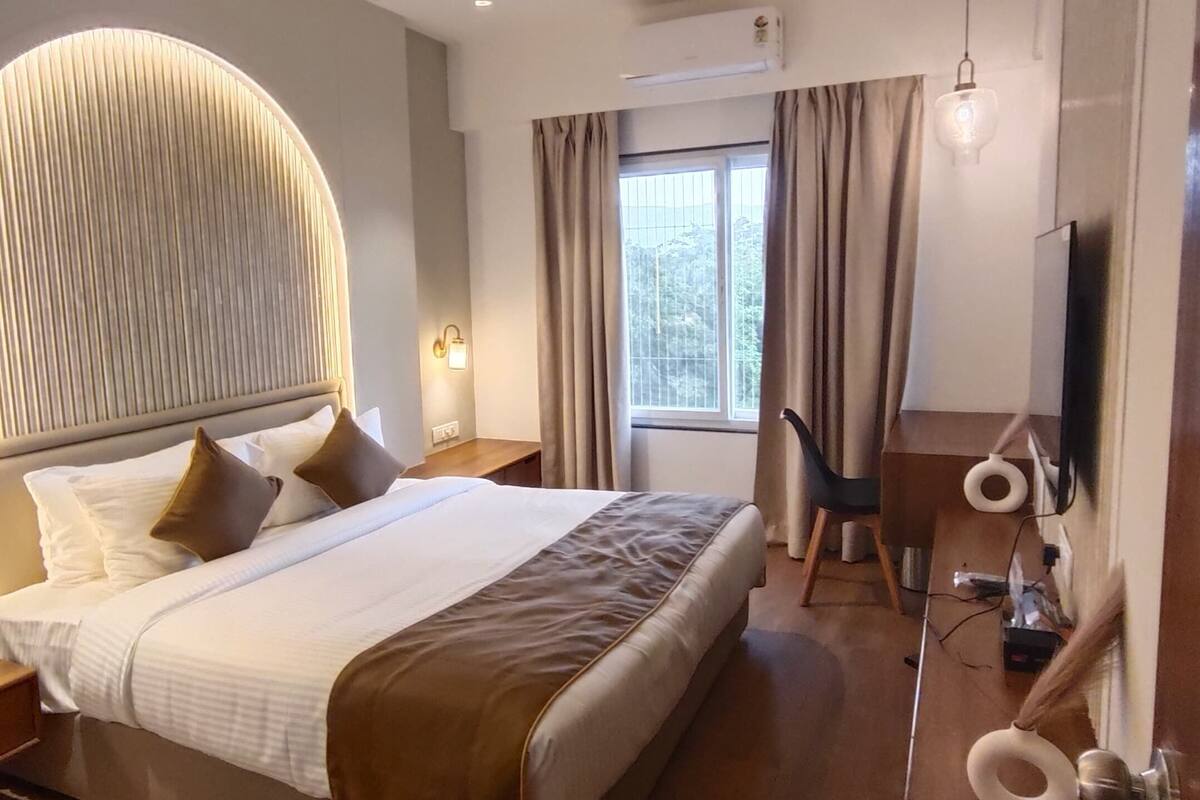Una habitación de hotel moderna con una cama grande, un escritorio y un espejo.
