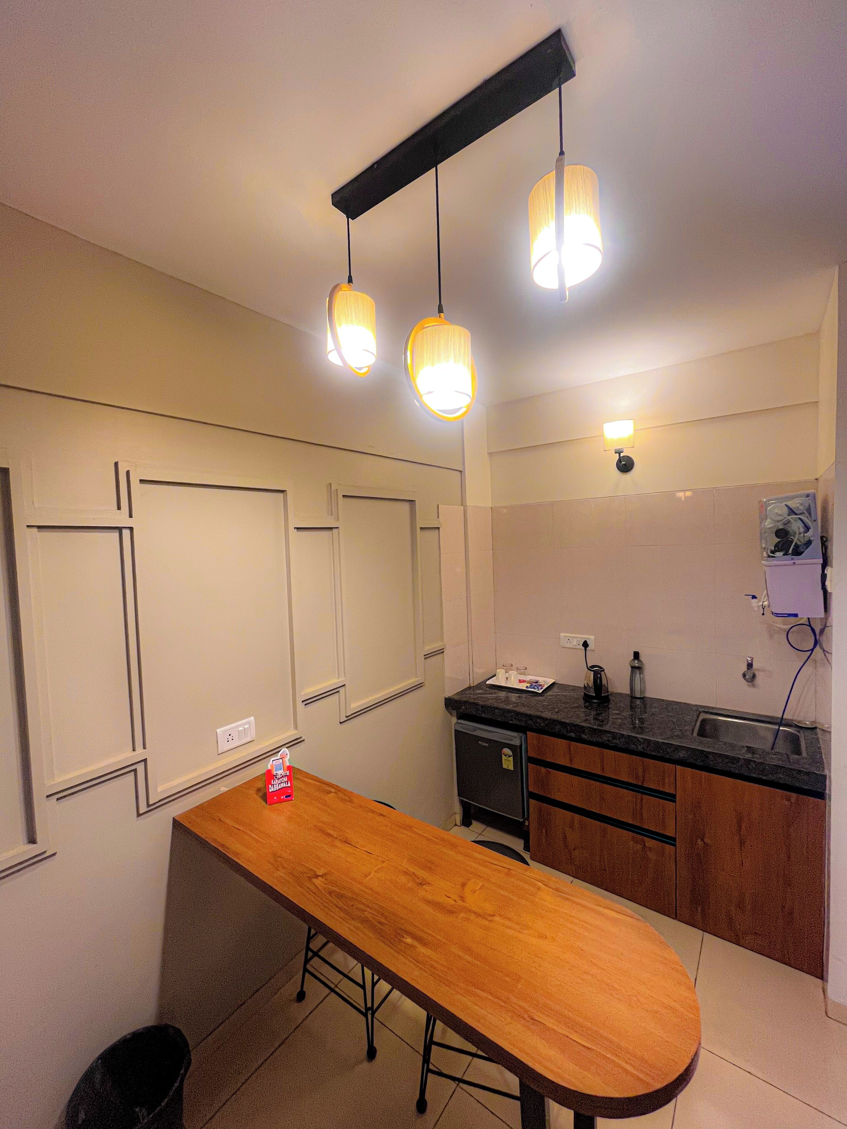 Una cocina compacta con mostrador de madera, un refrigerador pequeño y un lavamanos.